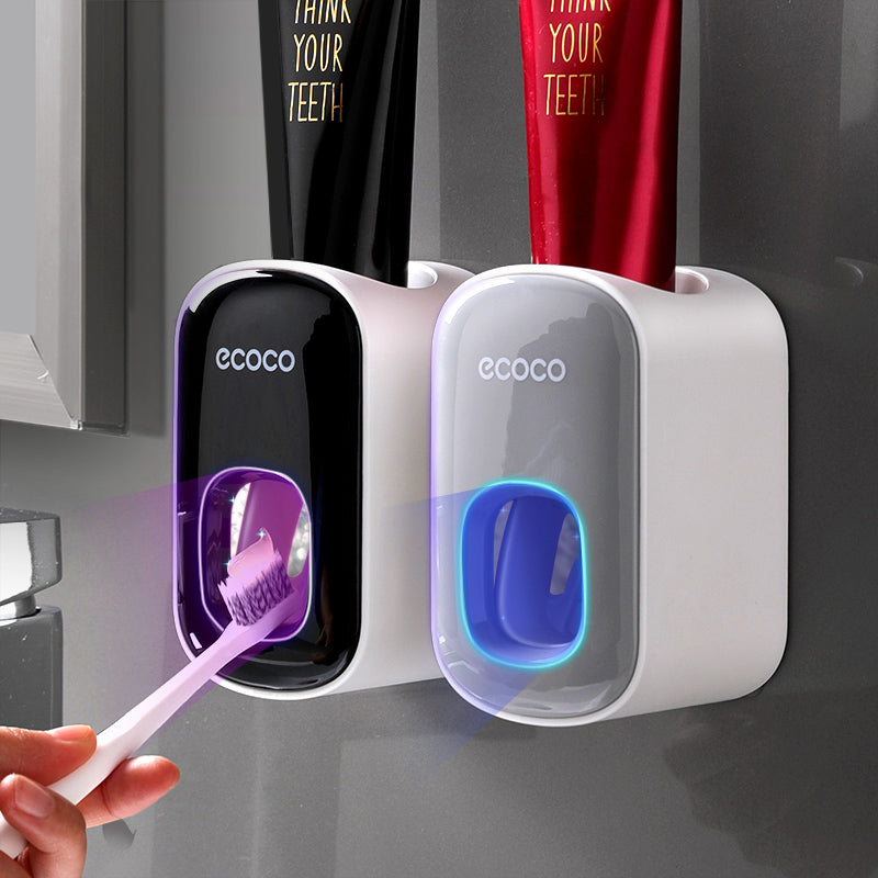 Jivolta Two ecoco toothbrush holders with a hand holding a purple toothbrush against a gray background.
